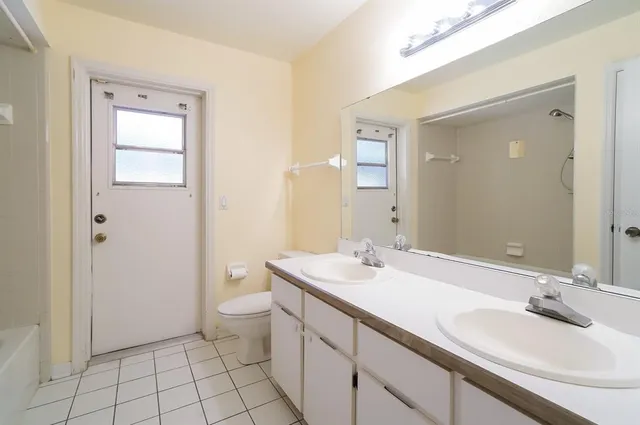 a bathroom with a sink a toilet and a mirror