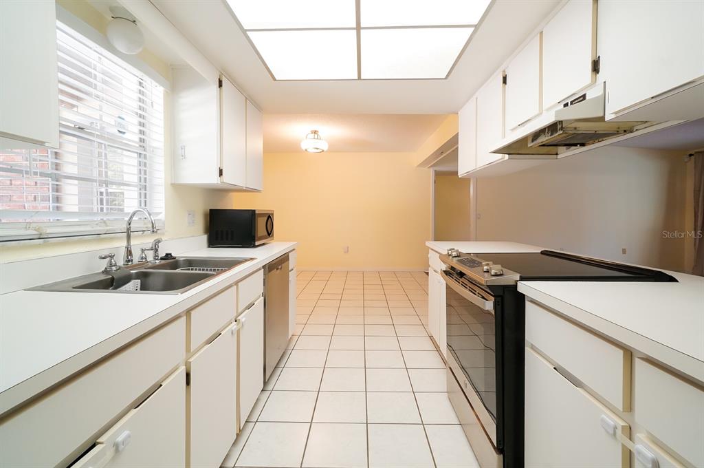 6260 Morning Mist Lane Orlando, FL 32819 - Photo 4 of 27 a kitchen with stainless steel appliances a sink a stove and a wooden floors