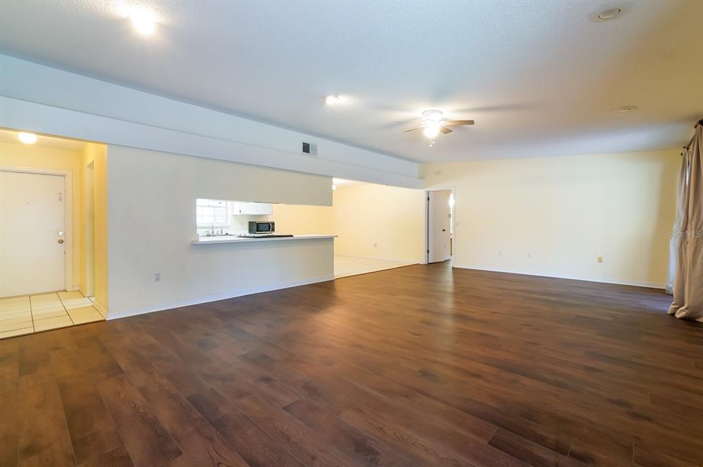 6260 Morning Mist Lane Orlando, FL 32819 - Photo 9 of 27 an empty room with wooden floor cabinet and windows
