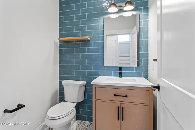 a bathroom with a sink toilet and mirror