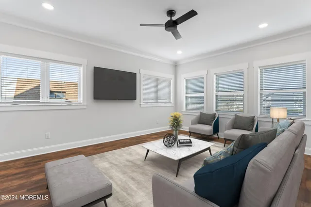 a living room with furniture a flat screen tv and a window