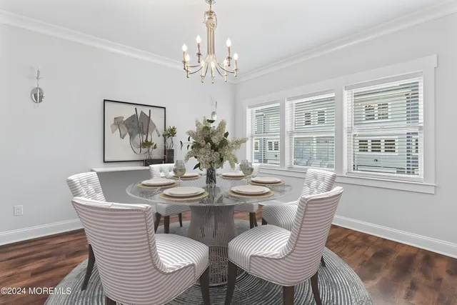 a view of a dining room with furniture a chandelier and wooden floor