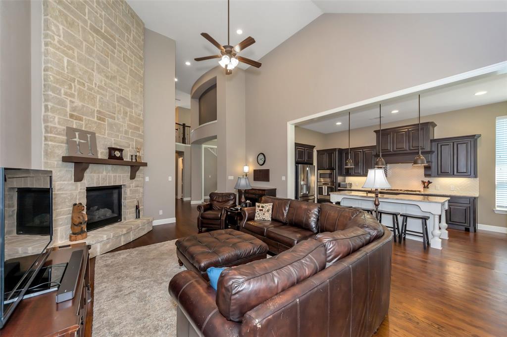 1001 West Bluff Way Roanoke, TX 76262 - Photo 18 of 40 Living room featuring ceiling fan, a stone fireplace, dark wood finished floors, high vaulted ceiling, and recessed lighting