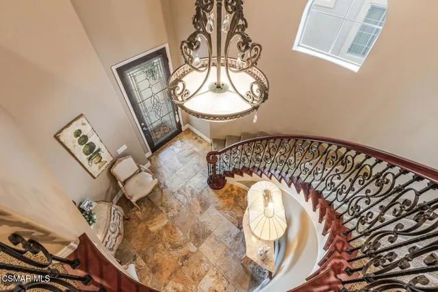 a view of staircase with a chandelier and wooden floor