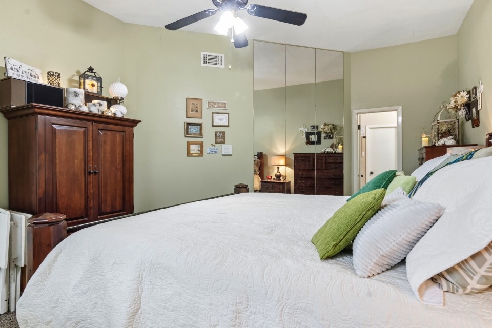 9211 Benwick Street Spring, TX 77379 - Photo 15 of 27 a bedroom with a bed and a chandelier