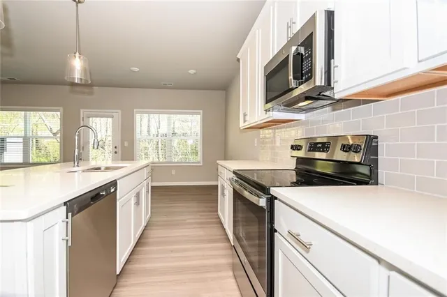 a kitchen with stainless steel appliances a stove a sink and a microwave