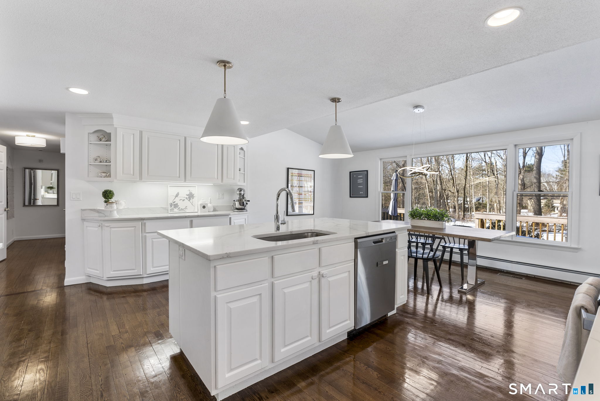 24 Ichabod Road Simsbury, CT 06070 - Photo 6 of 43 a kitchen with kitchen island granite countertop a stove a sink a dining table and chairs with wooden floor