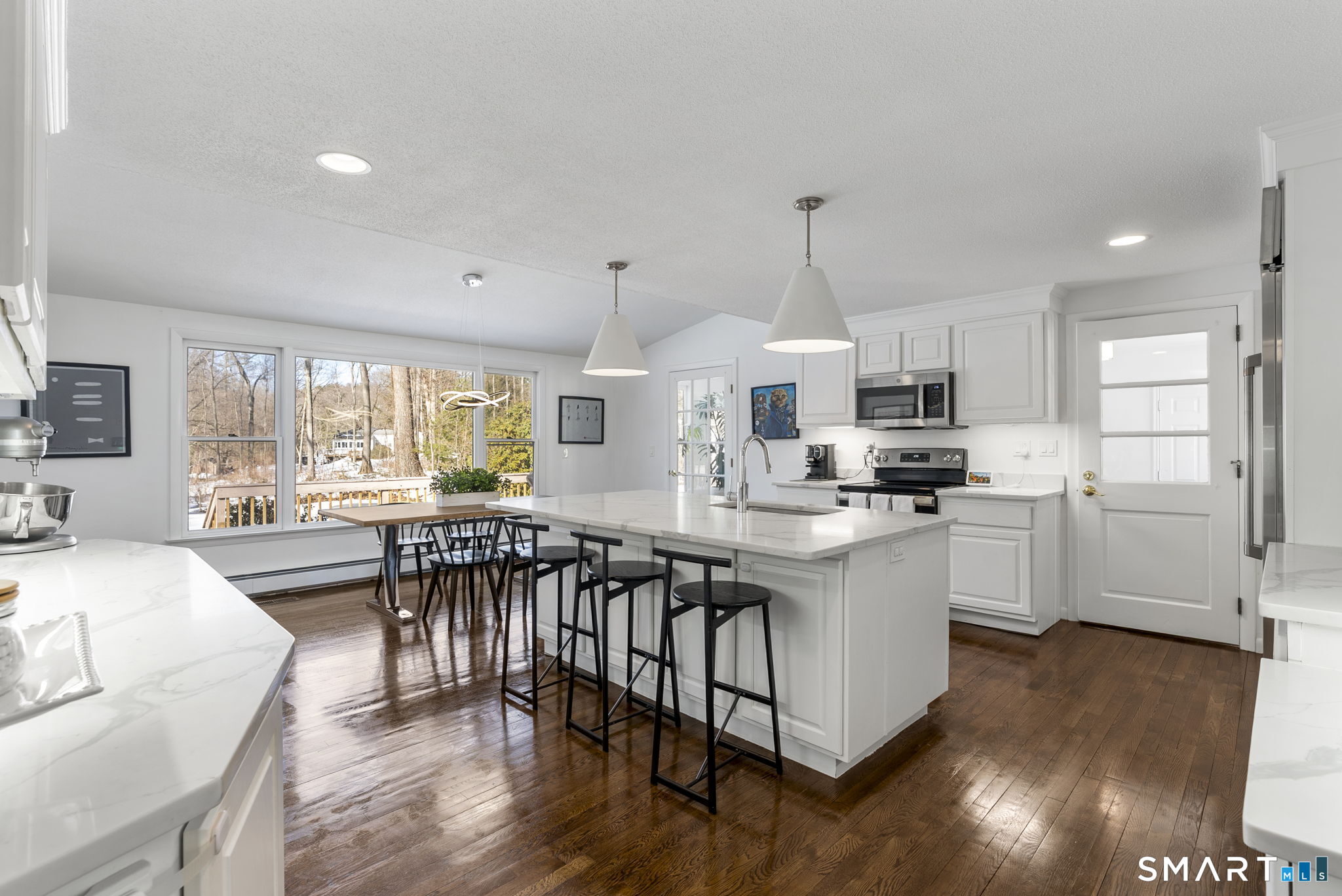 24 Ichabod Road Simsbury, CT 06070 - Photo 7 of 43 a kitchen with stainless steel appliances kitchen island granite countertop a stove a sink a refrigerator and white cabinets with wooden floor