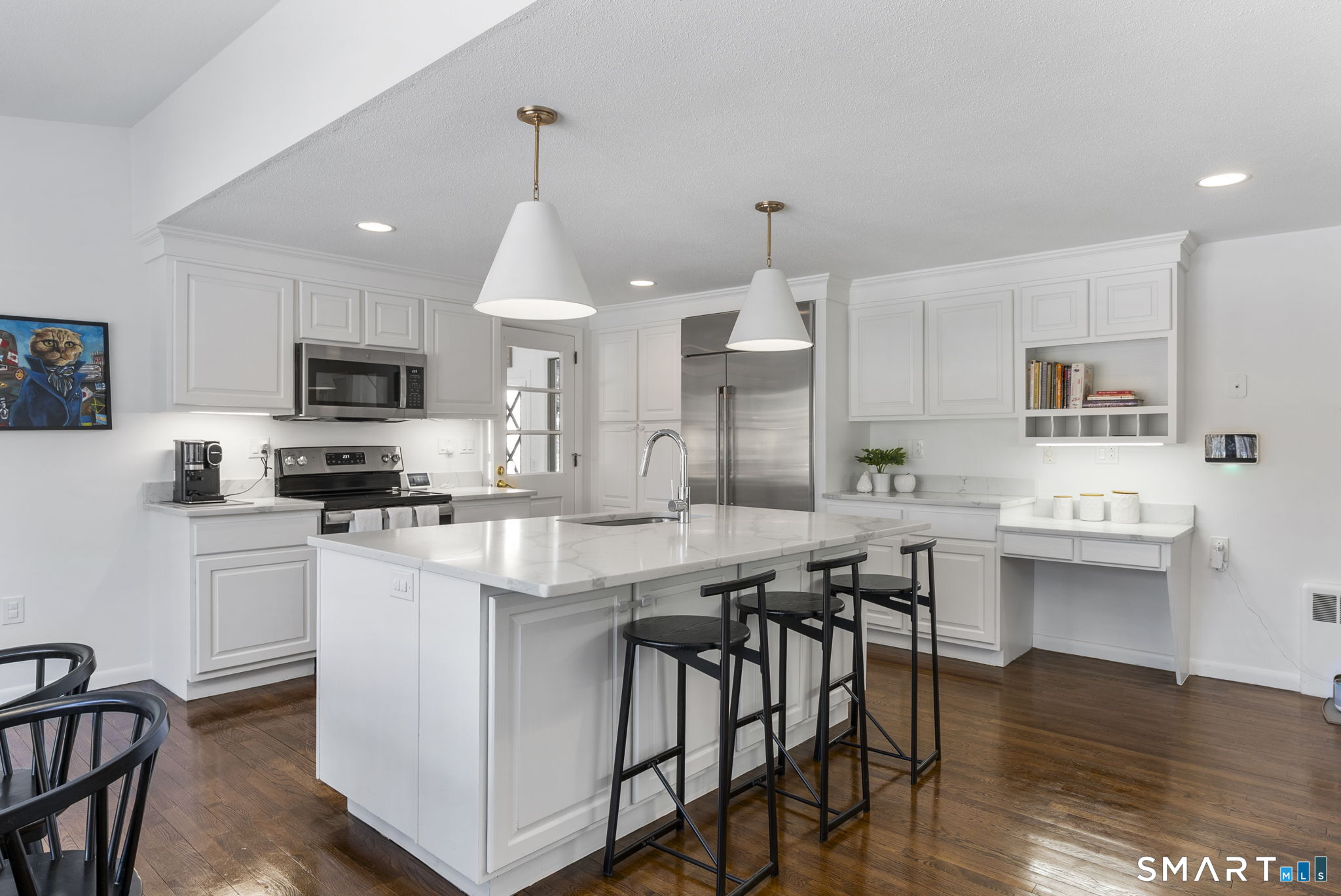 24 Ichabod Road Simsbury, CT 06070 - Photo 8 of 43 a kitchen with stainless steel appliances kitchen island granite countertop a stove a sink a dining table and chairs