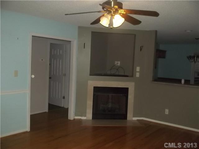 155 Kimball Road China Grove, NC 28023 - Photo 2 of 8 an empty room with a fireplace and chandelier fan