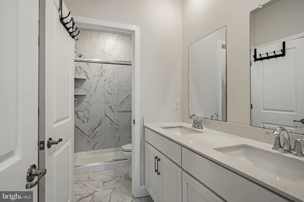 a bathroom with a granite countertop sink mirror and shower