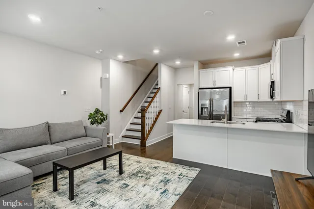 a living room with furniture and a dining table with wooden floor