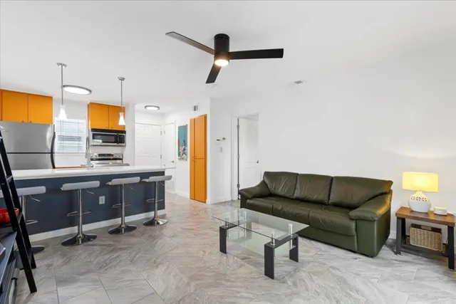 a living room with furniture a ceiling fan and a window