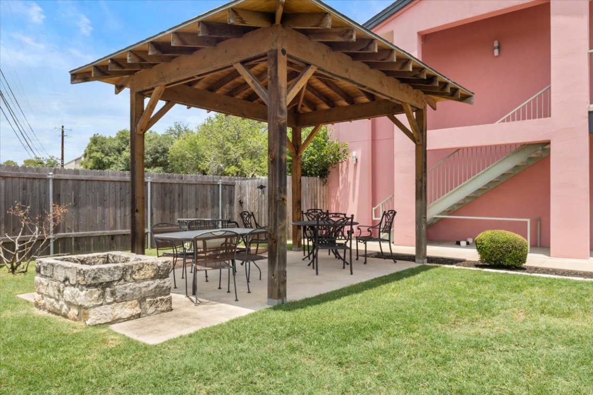 1422 Collier Street, Unit 103 Austin, TX 78704 - Photo 20 of 27 a view of a patio with table and chairs under an umbrella