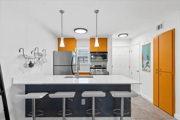 a kitchen with a table chairs refrigerator and microwave