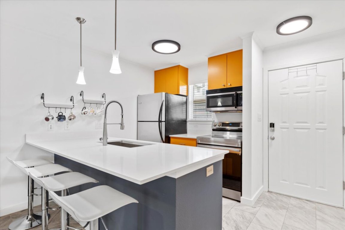 1422 Collier Street, Unit 103 Austin, TX 78704 - Photo 6 of 27 a kitchen with a sink cabinets and appliances