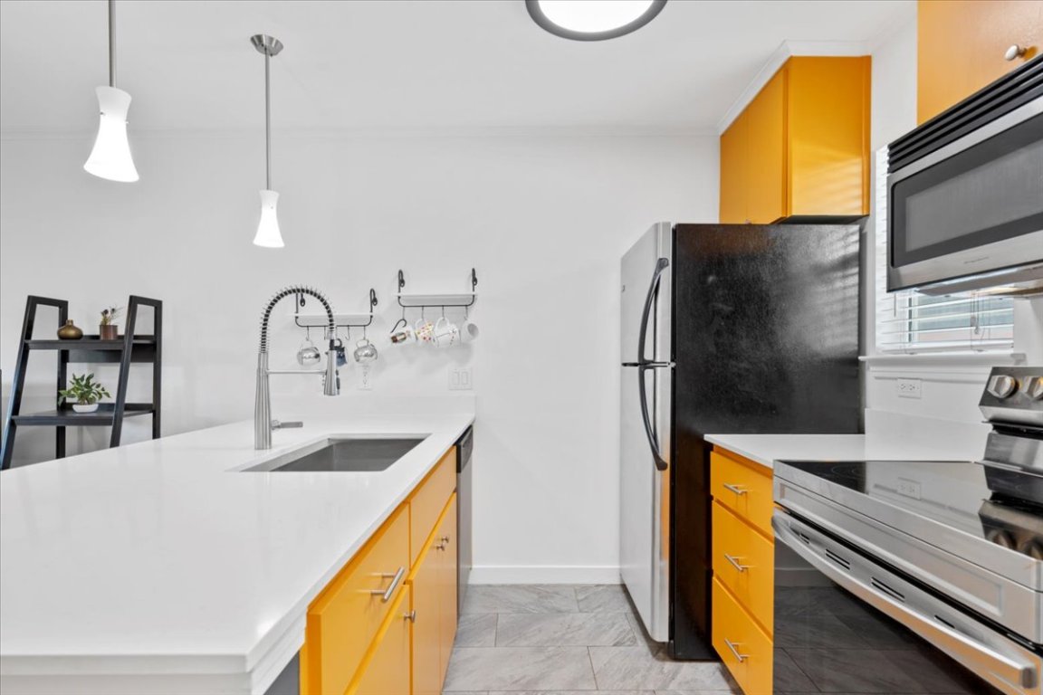 1422 Collier Street, Unit 103 Austin, TX 78704 - Photo 9 of 27 a kitchen with stainless steel appliances granite countertop a sink a stove and a refrigerator