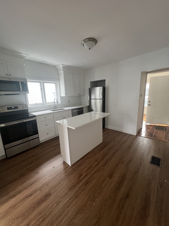 a kitchen with wooden floors and white appliances