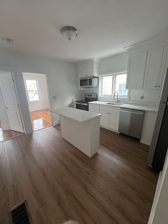 83 1/2 Summer Street, Unit 1 Salem, MA 01970 - Photo 2 of 6 a room with wooden floors and white cabinets