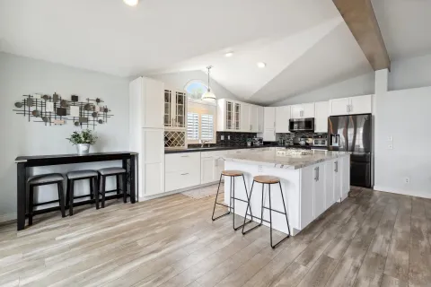 a kitchen with white cabinets and appliances