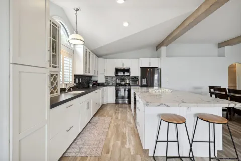 a large kitchen with kitchen island a large counter top space appliances and cabinets