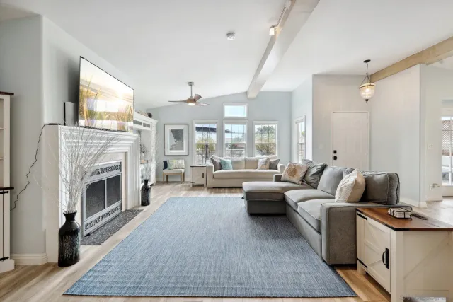 a living room with furniture large window and a fireplace