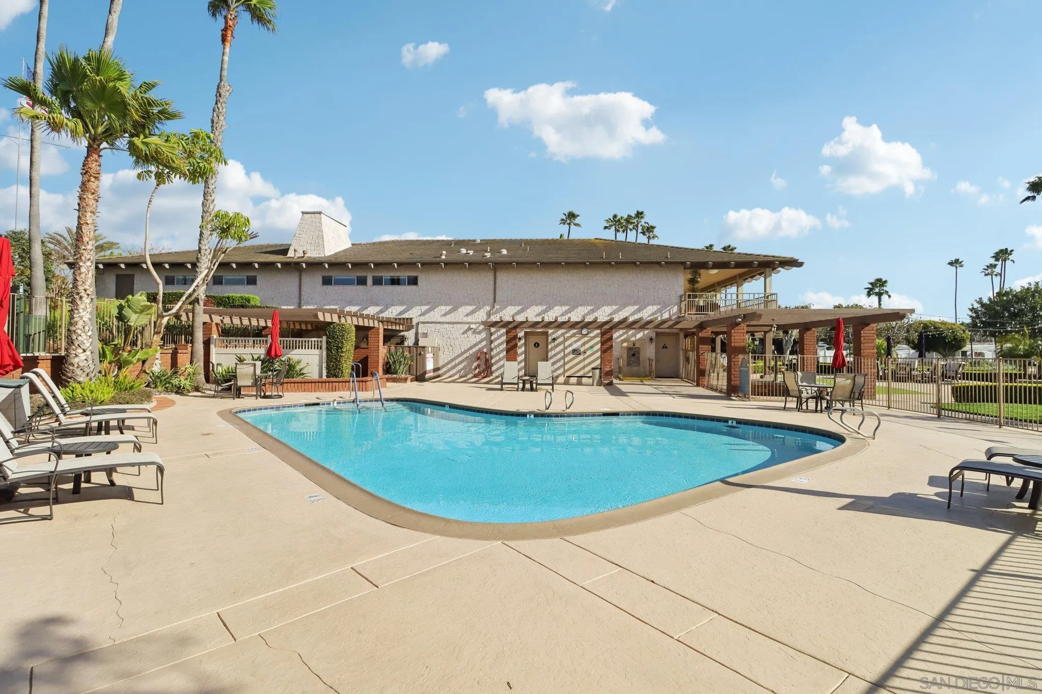 7002 San Bartolo Street, Unit 30 Carlsbad, CA 92011 - Photo 49 of 59 a view of a swimming pool with a table and chairs