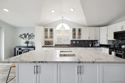 a kitchen with granite countertop a sink a stove and cabinets