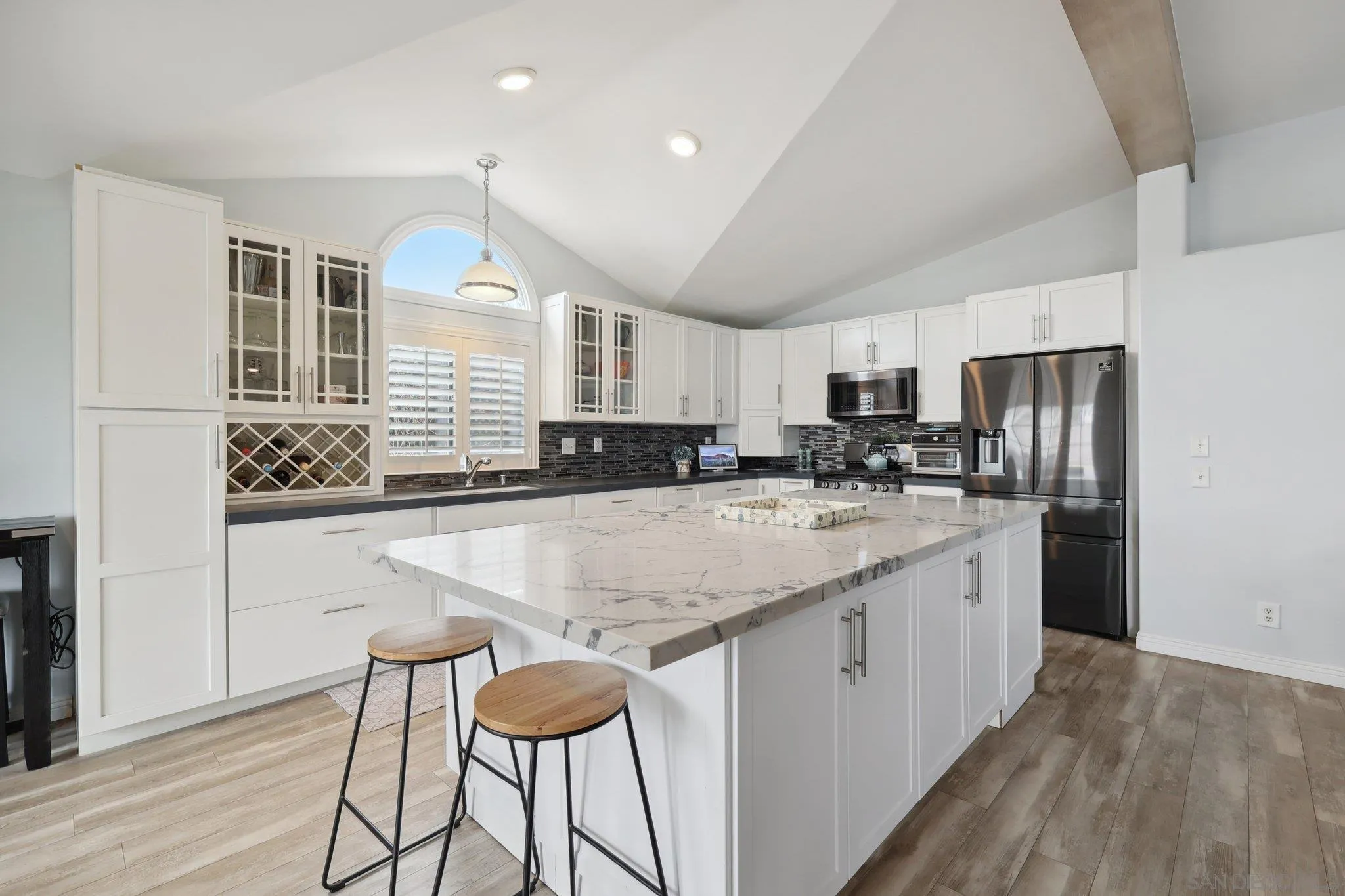 7002 San Bartolo Street, Unit 30 Carlsbad, CA 92011 - Photo 10 of 59 a kitchen with stainless steel appliances granite countertop a refrigerator a sink dishwasher a stove and white cabinets with wooden floor