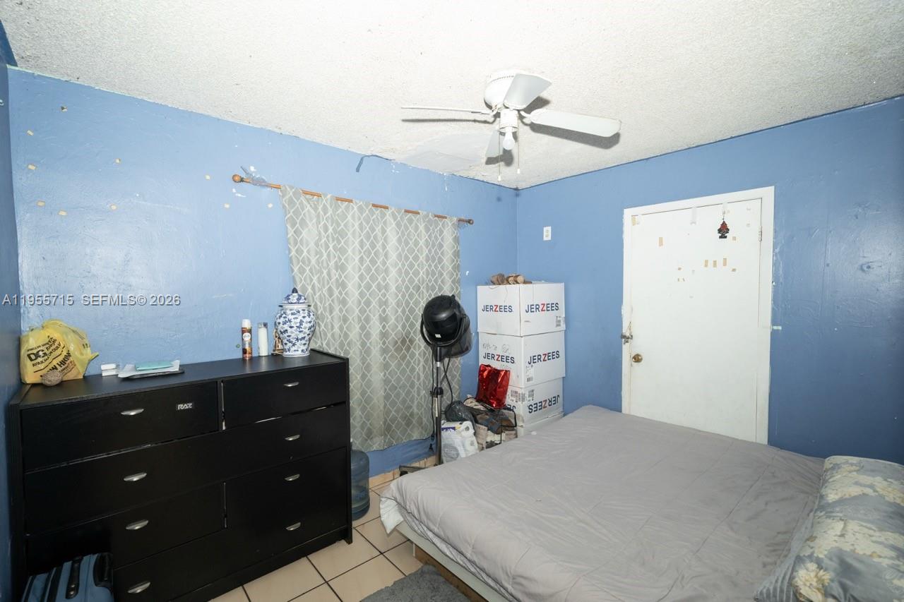671 East 6th Place Hialeah, FL 33010 - Photo 19 of 40 a bedroom with a bed and a chandelier
