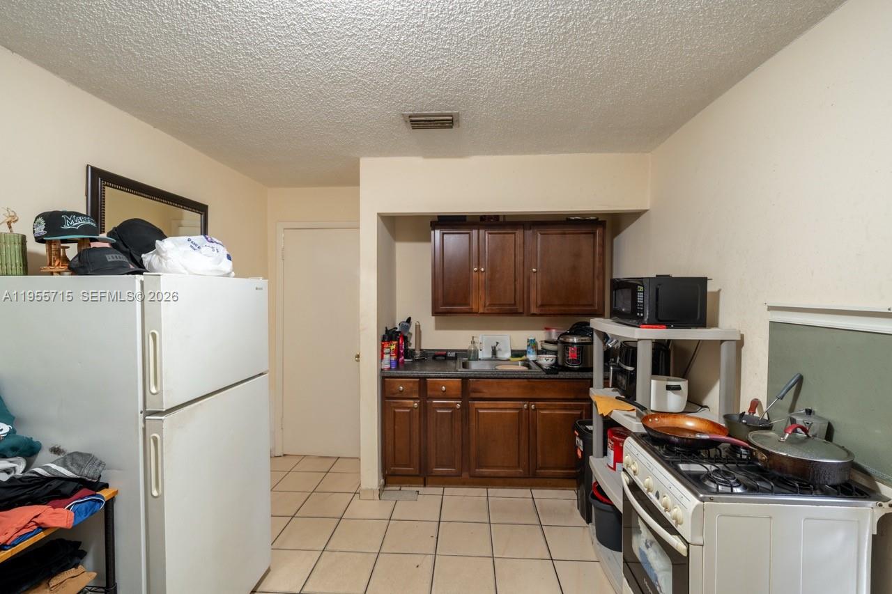671 East 6th Place Hialeah, FL 33010 - Photo 22 of 40 a kitchen with stainless steel appliances a stove and a refrigerator