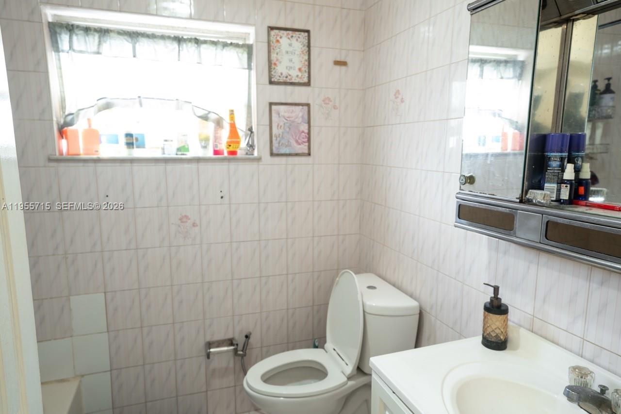671 East 6th Place Hialeah, FL 33010 - Photo 24 of 40 a bathroom with a toilet a sink and a window
