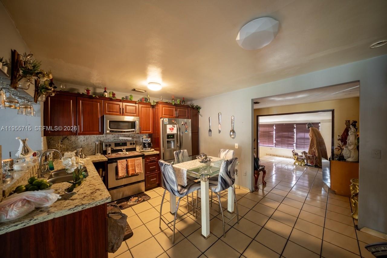 671 East 6th Place Hialeah, FL 33010 - Photo 10 of 40 a living room with furniture a flat screen tv and a window