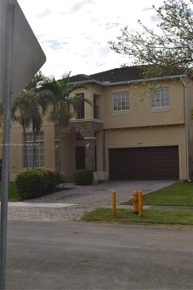 22418 Southwest 94th Path Cutler Bay, FL 33190 - Photo 1 of 71 a front view of a house with a yard and garage