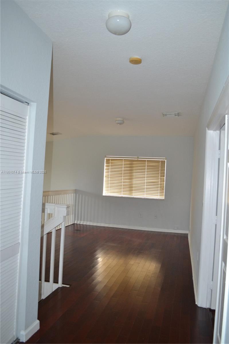 22418 Southwest 94th Path Cutler Bay, FL 33190 - Photo 17 of 71 a view of an empty room with wooden floor and a window