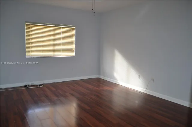 a view of a room with wooden floor and a window