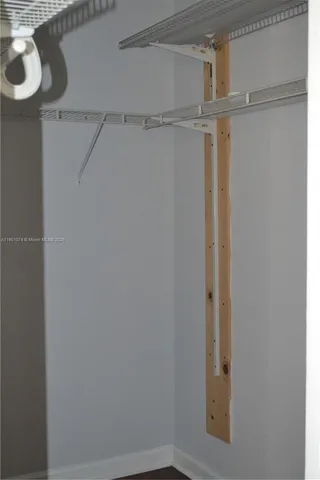 an empty room with wooden floor & closet area