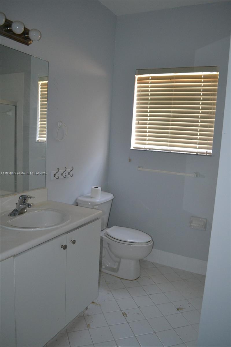 22418 Southwest 94th Path Cutler Bay, FL 33190 - Photo 39 of 71 a bathroom with a toilet a sink and a window