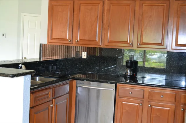 a kitchen with granite countertop a sink and cabinets