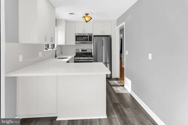 a kitchen with a refrigerator a stove a microwave and cabinets