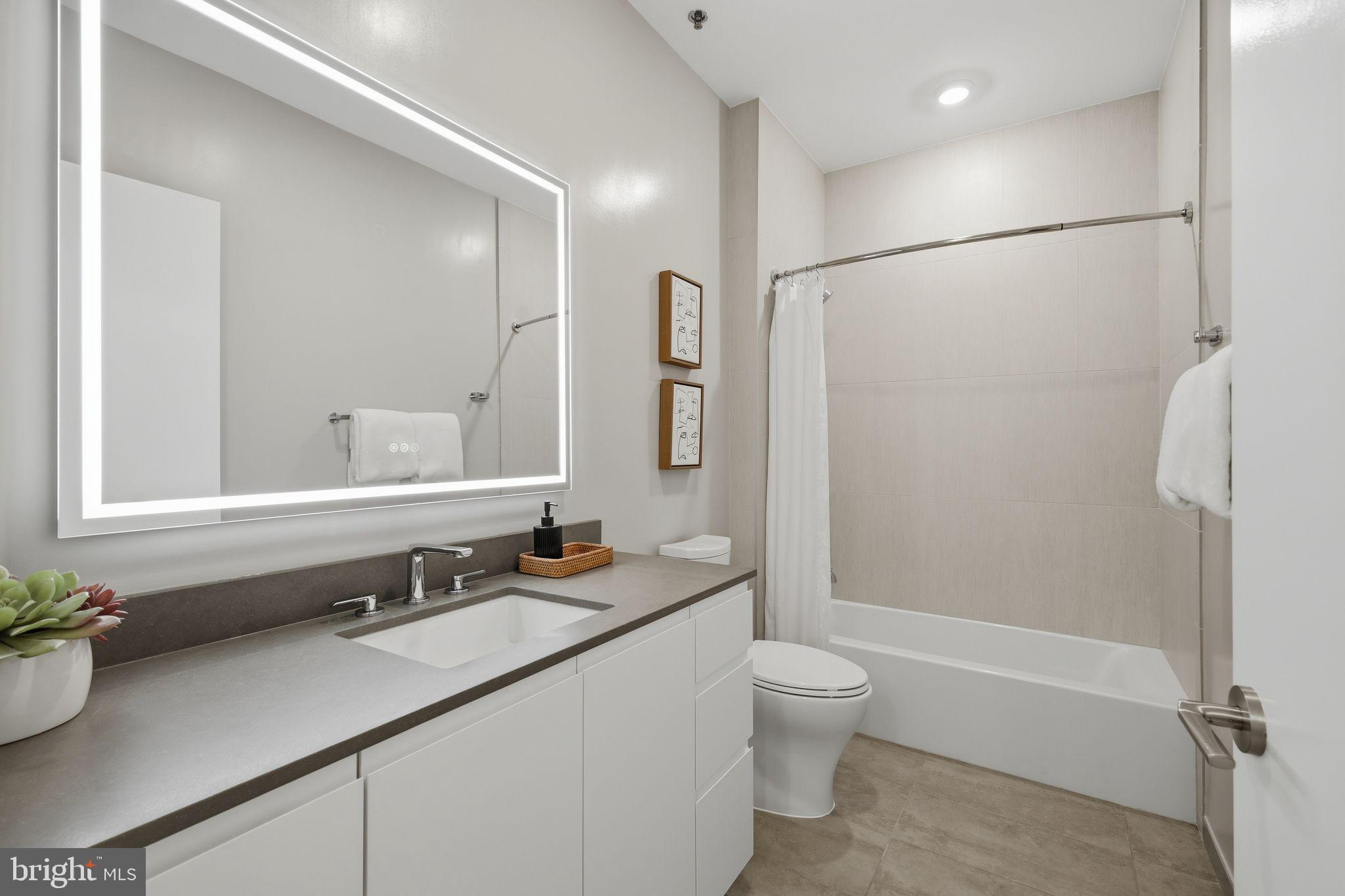 950 3rd Street Northwest, Unit 103 Washington, DC 20001 - Photo 31 of 32 a bathroom with a double vanity sink toilet mirror and shower