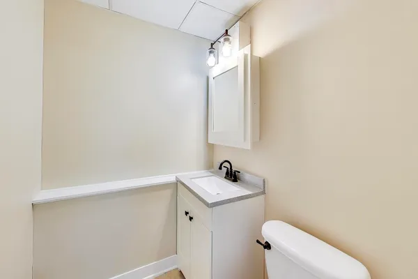 a bathroom with a sink a toilet and mirror