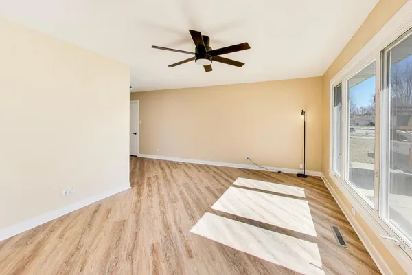 a view of a room with wooden floor and a ceiling fan