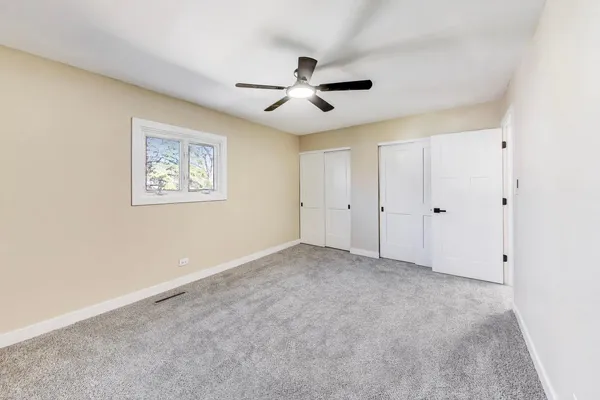 a view of an empty room with a ceiling fan