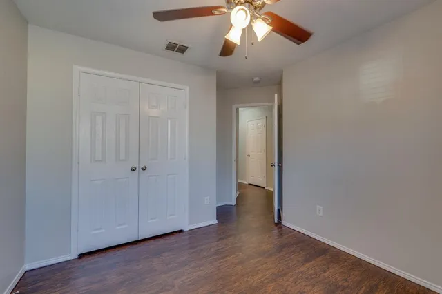a view of a livingroom with a fan a ceiling fan with wooden floor and a window