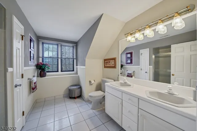 a bedroom with a bed and a flat tv screen on dresser