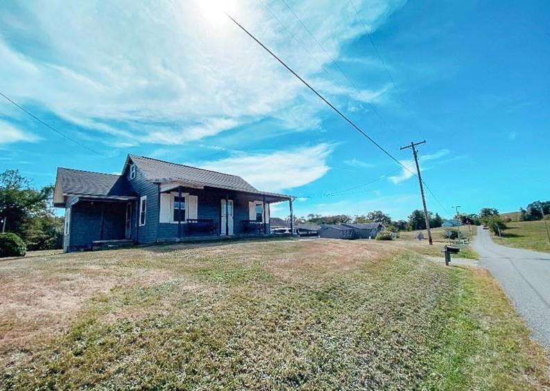 a view of a house with a big yard and a large tree