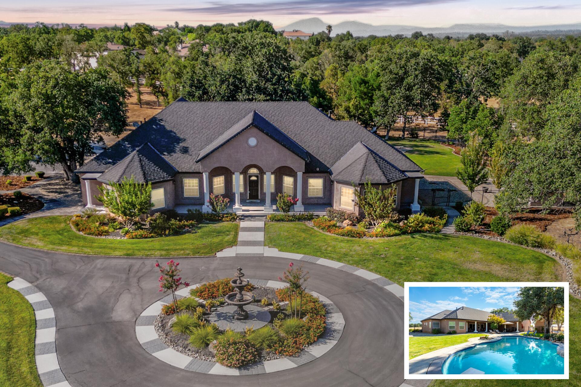 a view of a big house with a big yard and potted plants