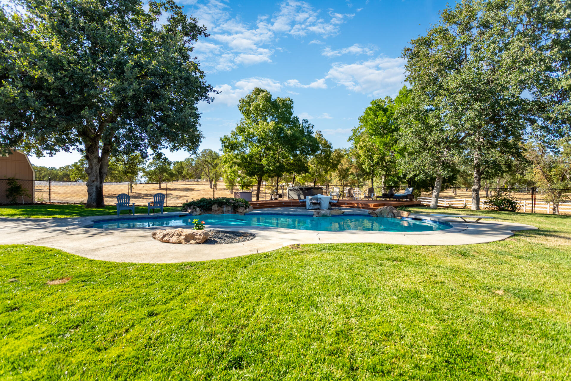 7307 Del Rico Court Palo Cedro, CA 96073 - Photo 34 of 55 a view of a swimming pool with outdoor seating and trees in the background