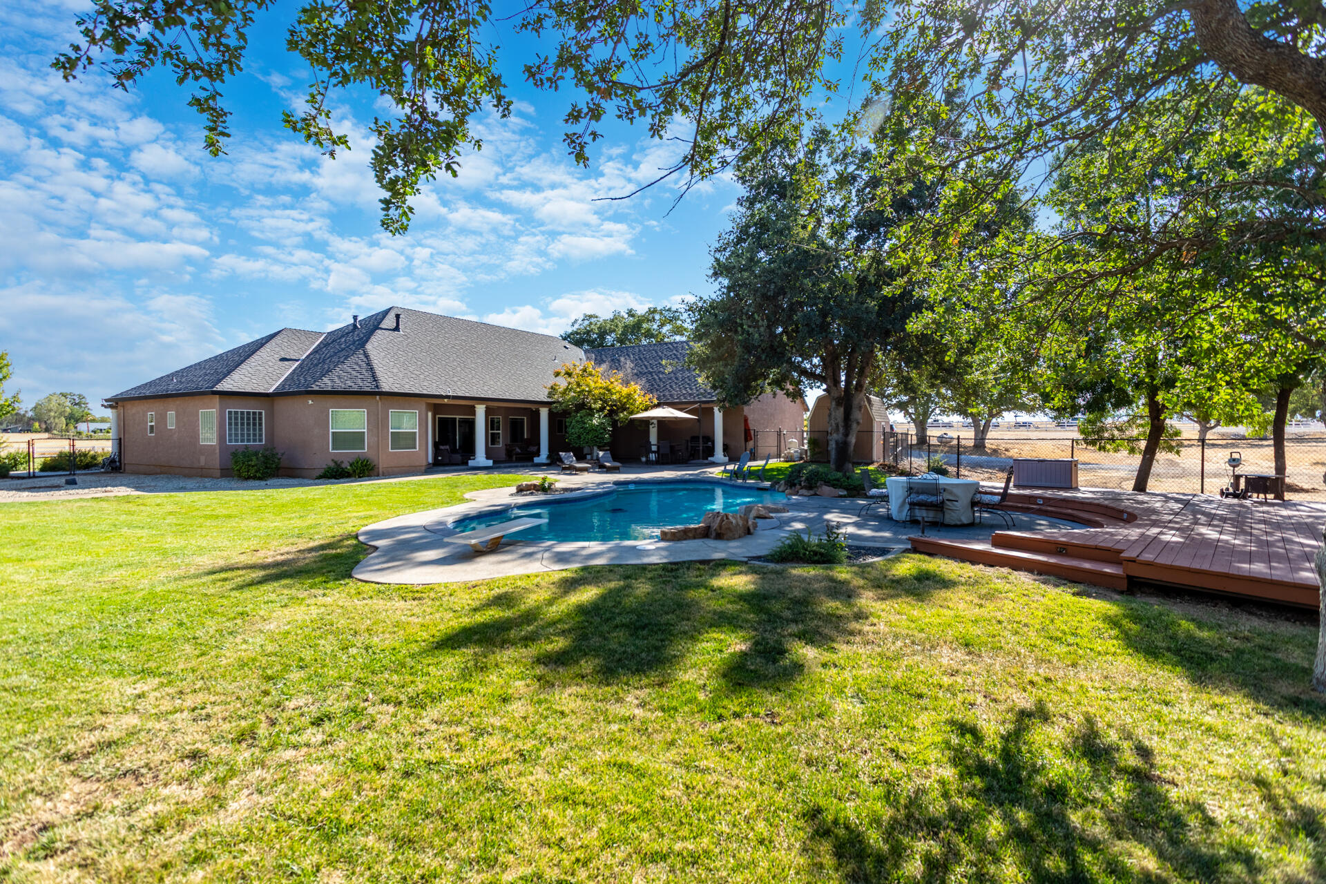 7307 Del Rico Court Palo Cedro, CA 96073 - Photo 38 of 55 a view of a swimming pool with lawn chairs under an umbrella